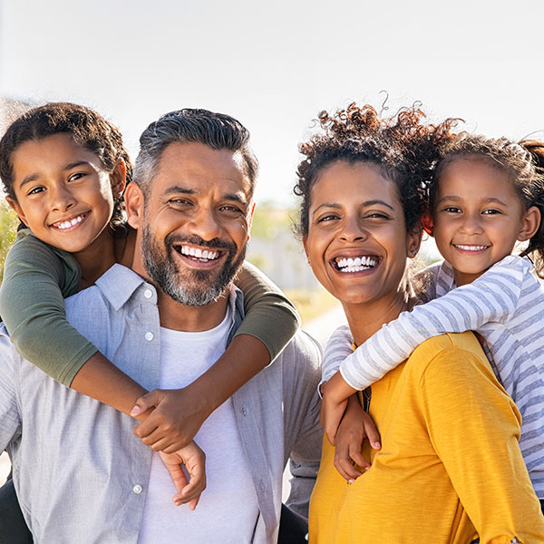 Family smiling & hugging outside